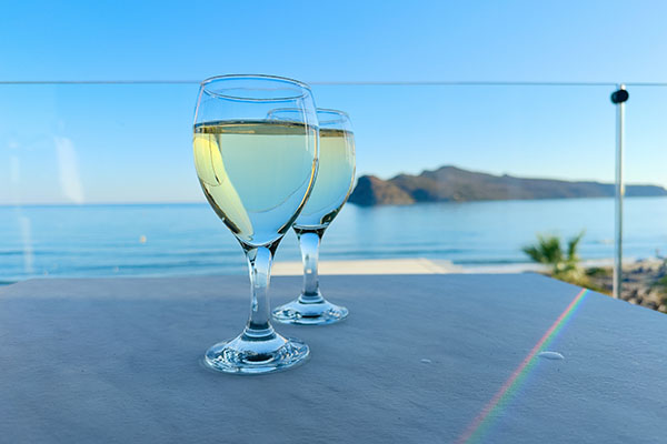 Two glasses of cretan wine on Agia Marina beach, Crete Greece