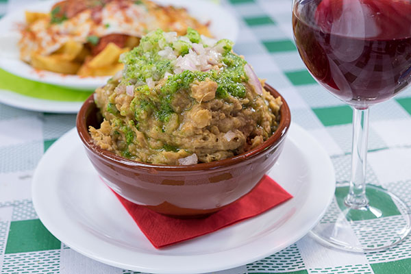Bowl of gofio escaldon with a glass of wine