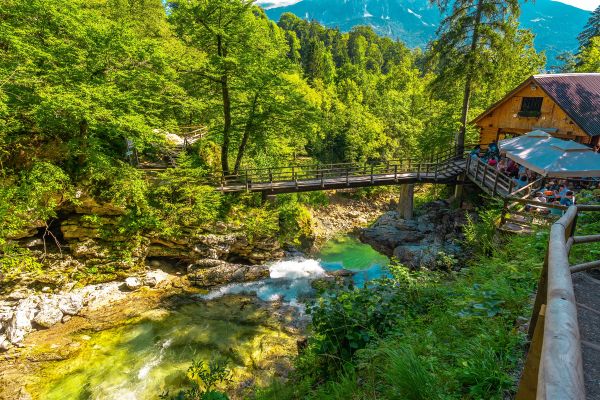 Wooden bridge and restaurant above radovna river flowing through vintgar gorge near bled